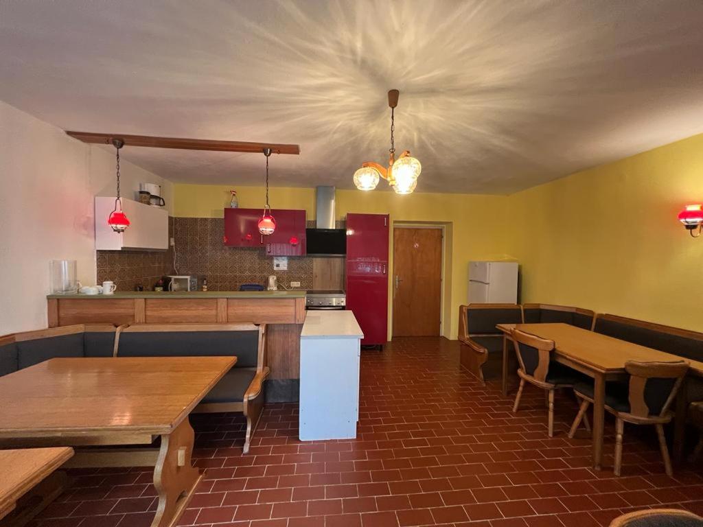 a restaurant with wooden tables and a kitchen with a counter at Pension Strasser in Bad Schallerbach