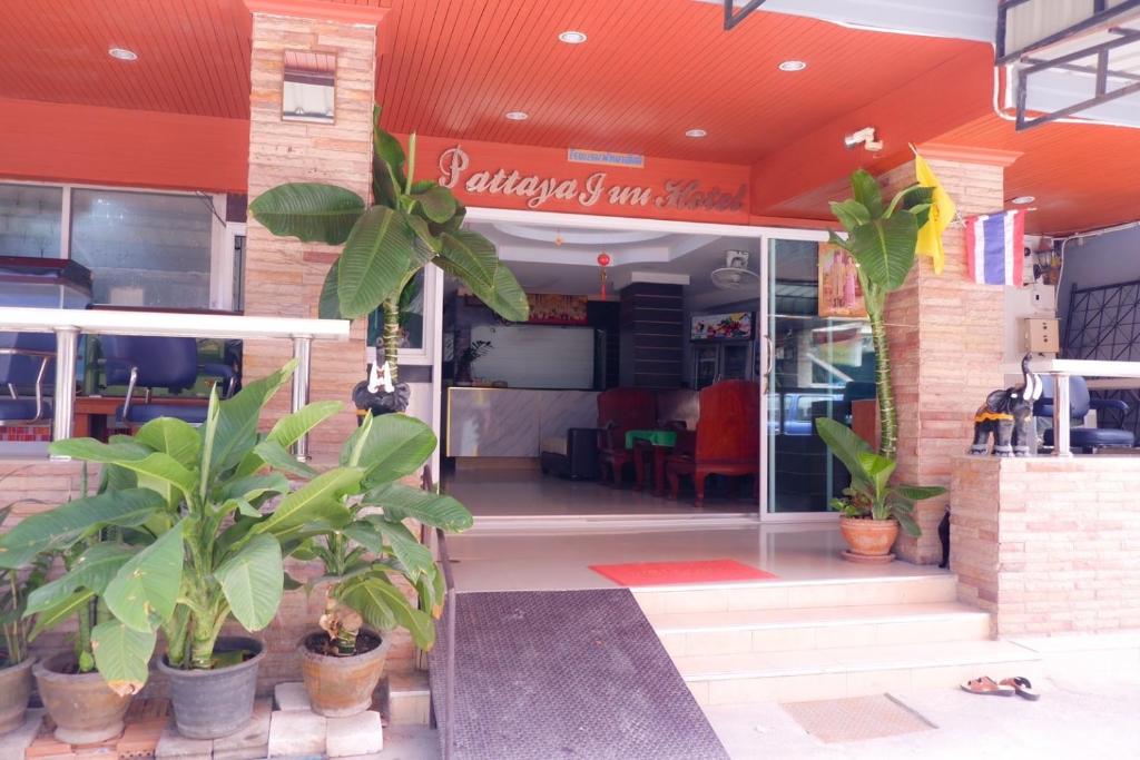 Pattaya inn hotel في جنوب باتايا: واجهة متجر بالنباتات أمامه