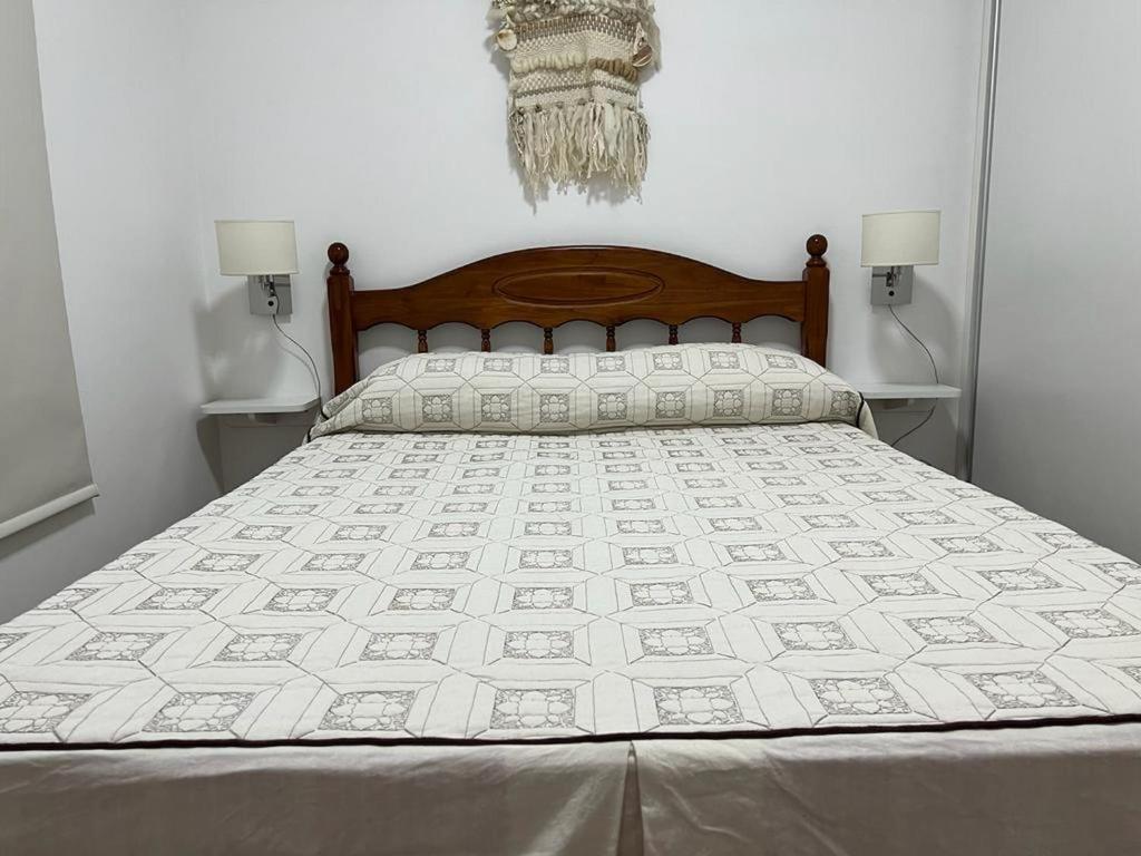 een slaapkamer met een bed met een witte sprei bij Departamento en Bragado B in Bragado
