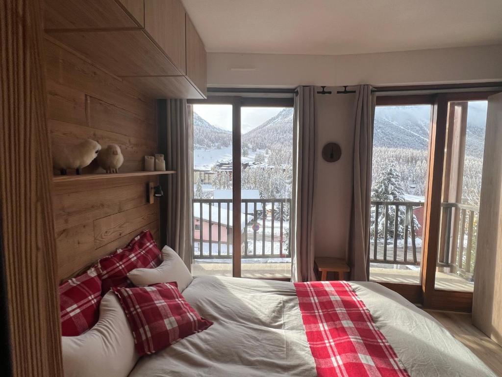 1 dormitorio con 1 cama con almohadas rojas y blancas en La Marmotte Duplex 4 p. entièrement rénové avec vue magnifique, en Montgenèvre