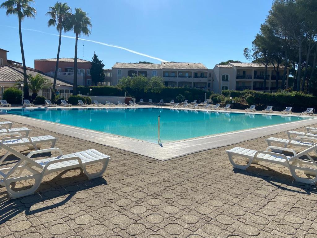 a large swimming pool with lounge chairs in a resort at Domaine Valescure Appartement 1 ou 2 pieces vue jardin ou piscine in Saint-Raphaël