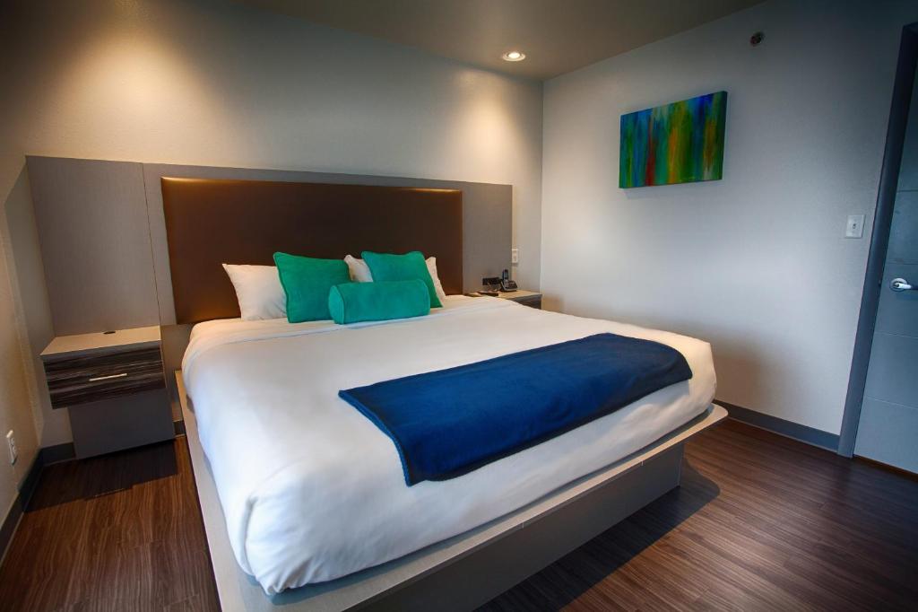 a bedroom with a large bed with blue and green pillows at Z Loft Extended Stay Hotel in Saint Robert