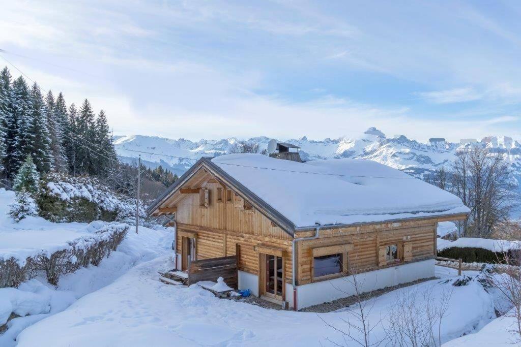 une cabane en rondins avec de la neige sur le toit dans l'établissement Chalet à Saint-Gervais-les-Bains, 8 personnes, 4 chambres, à Saint-Gervais-les-Bains
