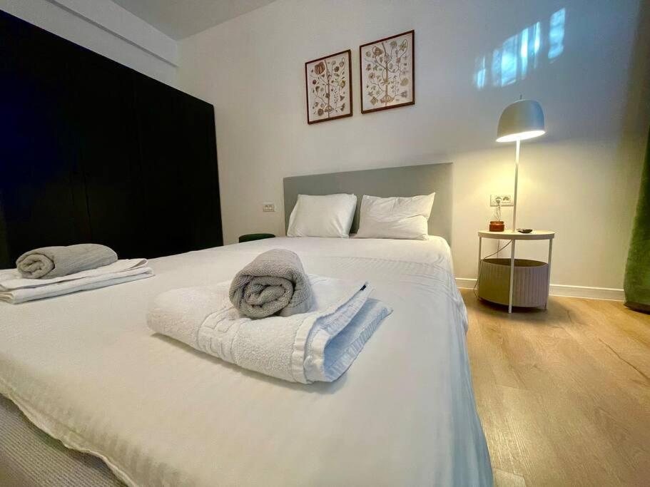 - une chambre avec un grand lit blanc et des serviettes dans l'établissement Sky Residence Airport Otopeni no 4, à Otopeni