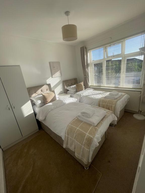 a bedroom with two beds and a window at The Peaceful Place in Cheshunt