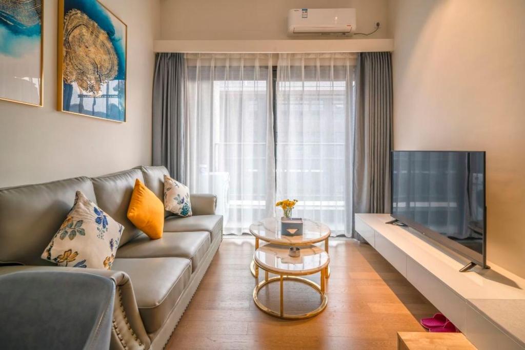 a living room with a couch and a tv at Guangzhou YuXiang Apartment - Guangzhou Pazhou International Convention and Exhibition Center in Guangzhou