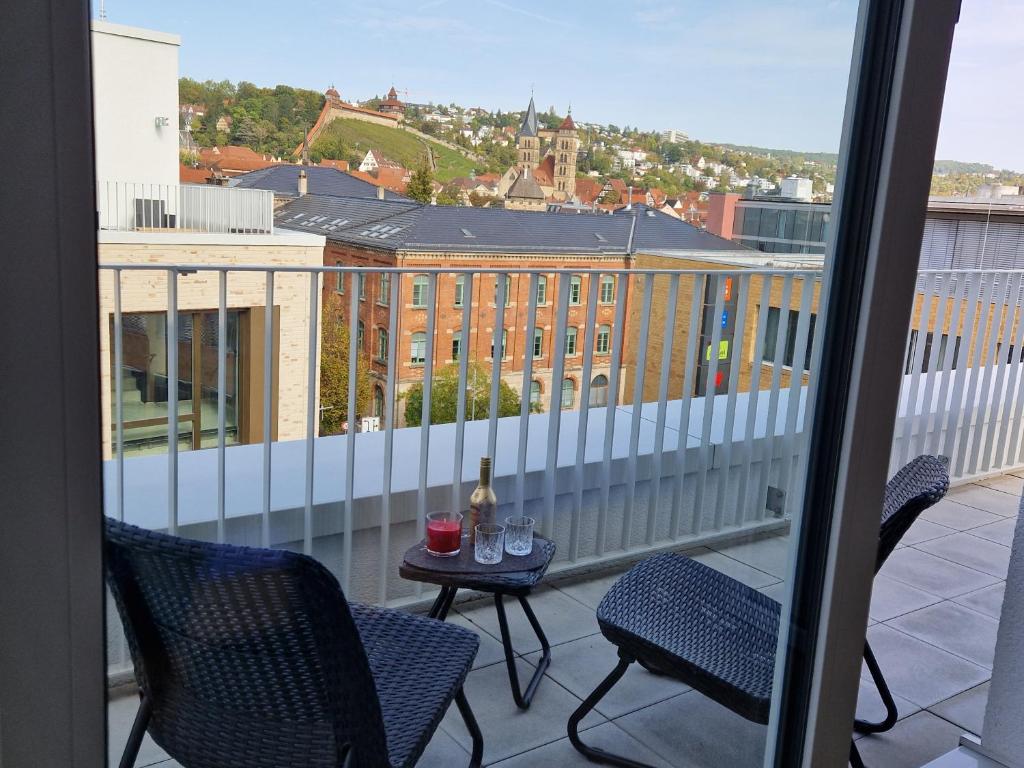 a balcony with two chairs and a table with glasses on it at Auszeit Penthouse-Feeling in Esslingen