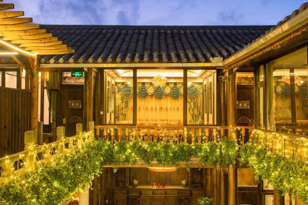 un edificio con un restaurante con plantas verdes en Tengchong Old Town Peace Inn en Tengchóng
