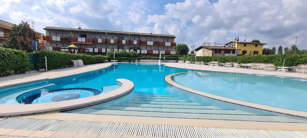 a large swimming pool in front of a hotel at Casa Belvì - Family Appartement Lugana-Sirmione in San Martino della Battaglia