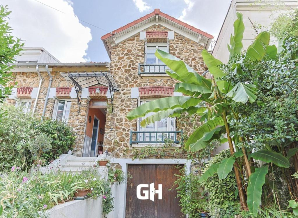 ein Backsteinhaus mit einer Holztür davor in der Unterkunft Le Marine - Maison avec jardin Disney & Paris in Le Perreux-sur-Marne