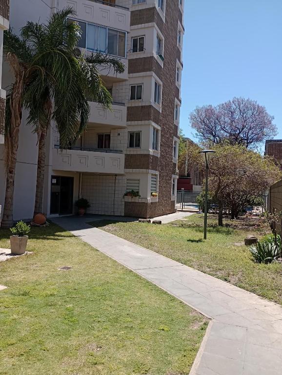 a building with a palm tree next to a sidewalk at La casa de Emma in Córdoba