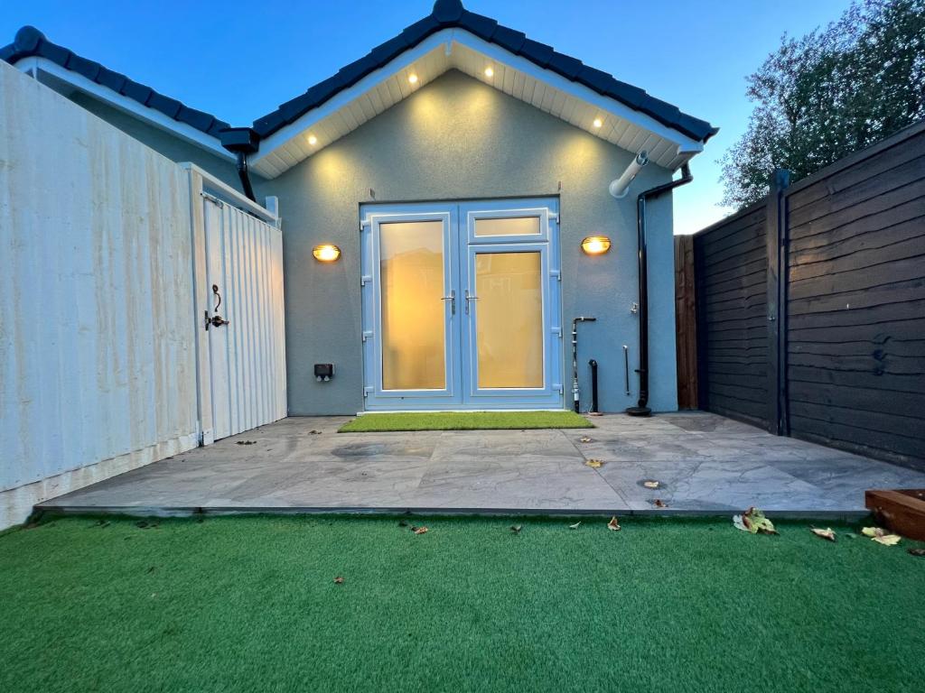 a house with a blue door and a yard at Cozy Luxury Private Cottage in Greenford