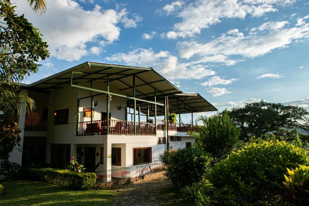 a house with a balcony on top of it at Ecohotel Monteverde in La Vega