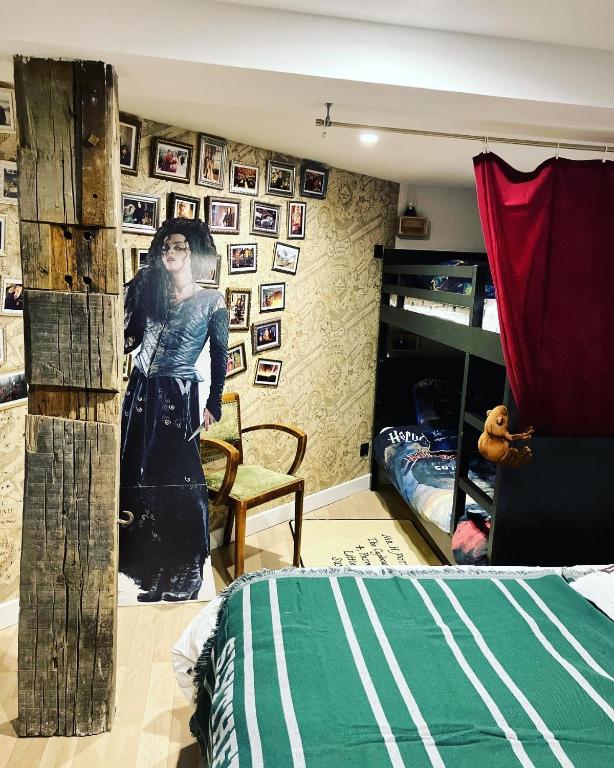 a bedroom with a bed and a wall with pictures at Les sorciers, la Diligence St Jean de Losne in Saint-Jean-de-Losne