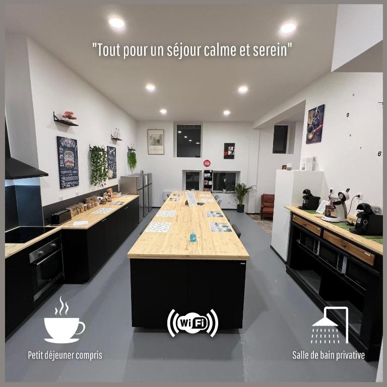 une grande cuisine avec une grande île au milieu dans l'établissement Les AGRIATES, à Besançon