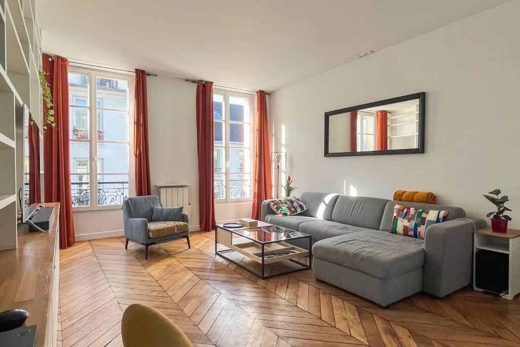un salon avec un canapé et une table dans l'établissement Luxurious Apartment in Marais, à Paris
