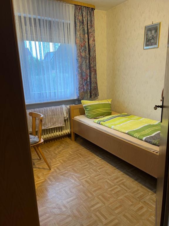 niewielka sypialnia z łóżkiem i oknem w obiekcie Einzel Zi Nr 2 w mieście Freiensteinau