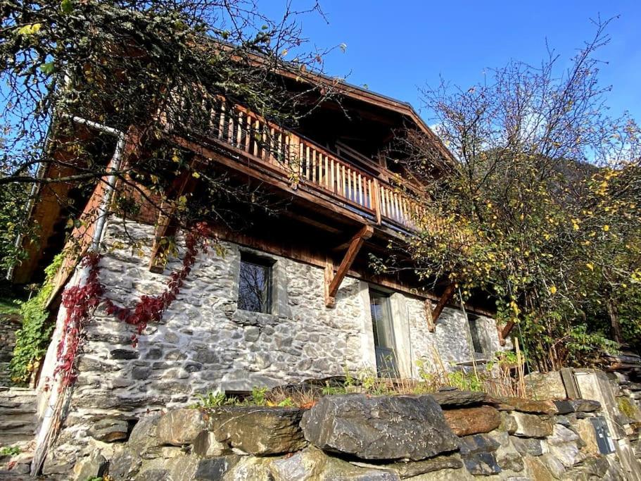 a stone house with a balcony on top of a stone wall at 300-year-old Farmhouse Chalet in Servoz