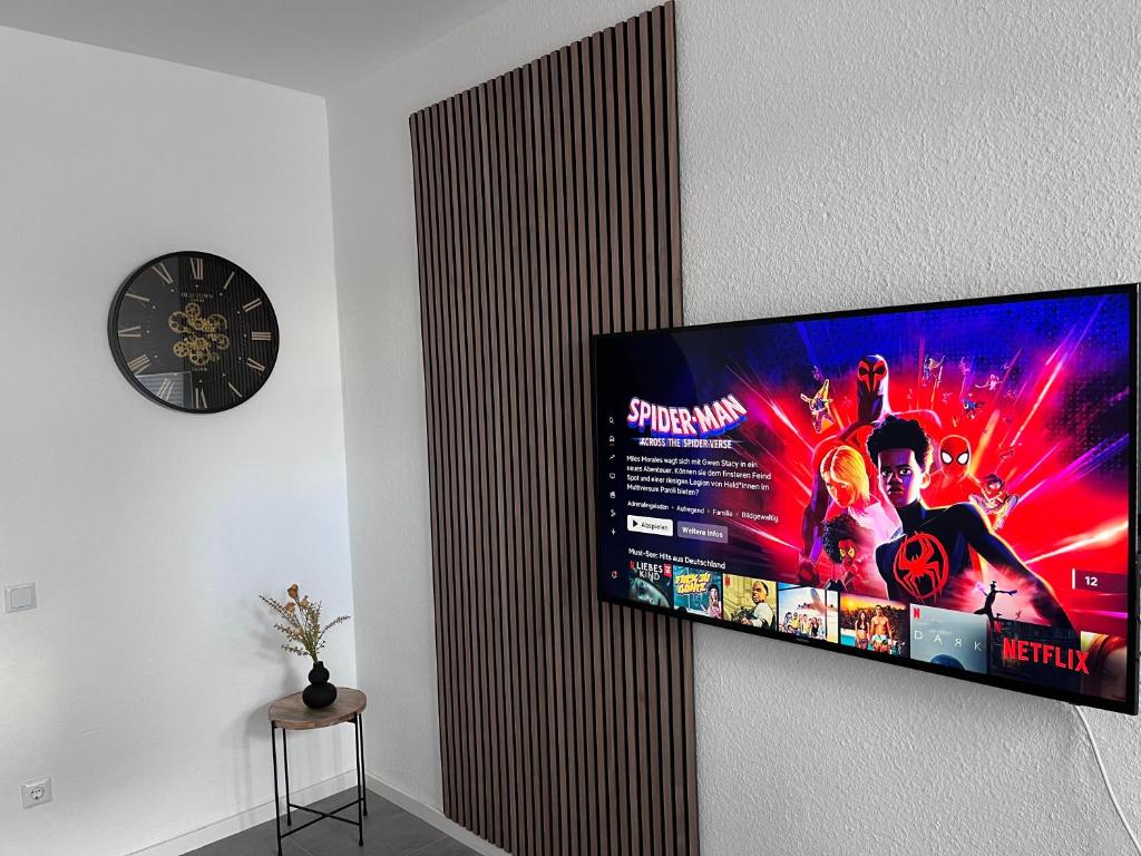 einen Flachbild-TV, der an einer Wand hängt in der Unterkunft Appartment Florida Nähe Düsseldorf, Messe, HBF, City, Netflix, WIFI, HELIOS Hospital in Krefeld