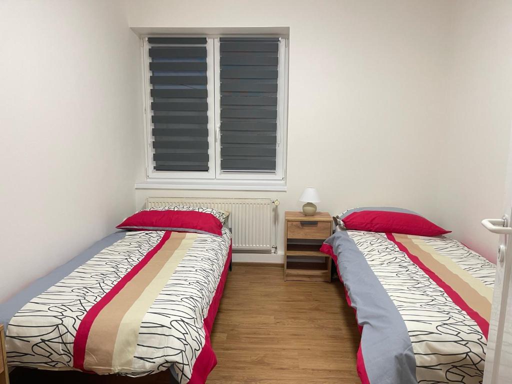 two beds in a room with a window at Restaurace Hamburk s ubytováním in Beroun