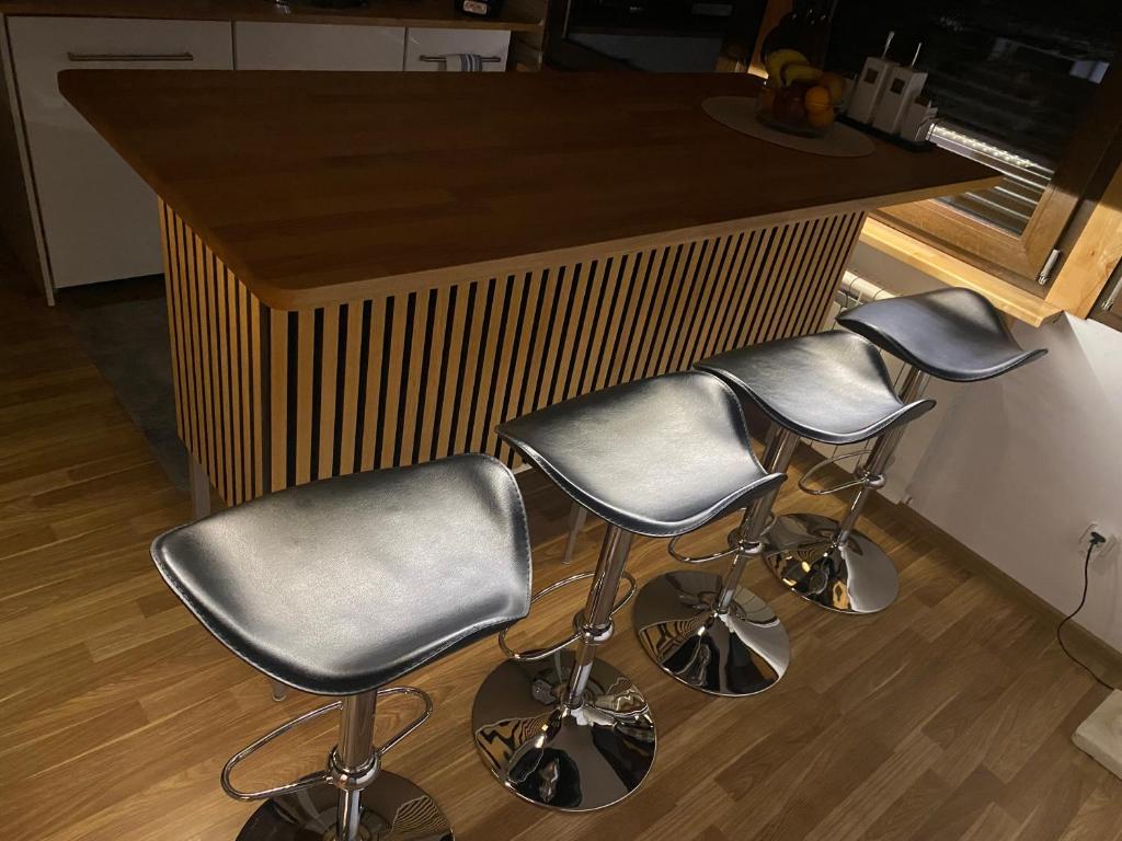 a kitchen with three bar stools in front of a counter at Unter dem Dach mit Parkplatz in Bremen