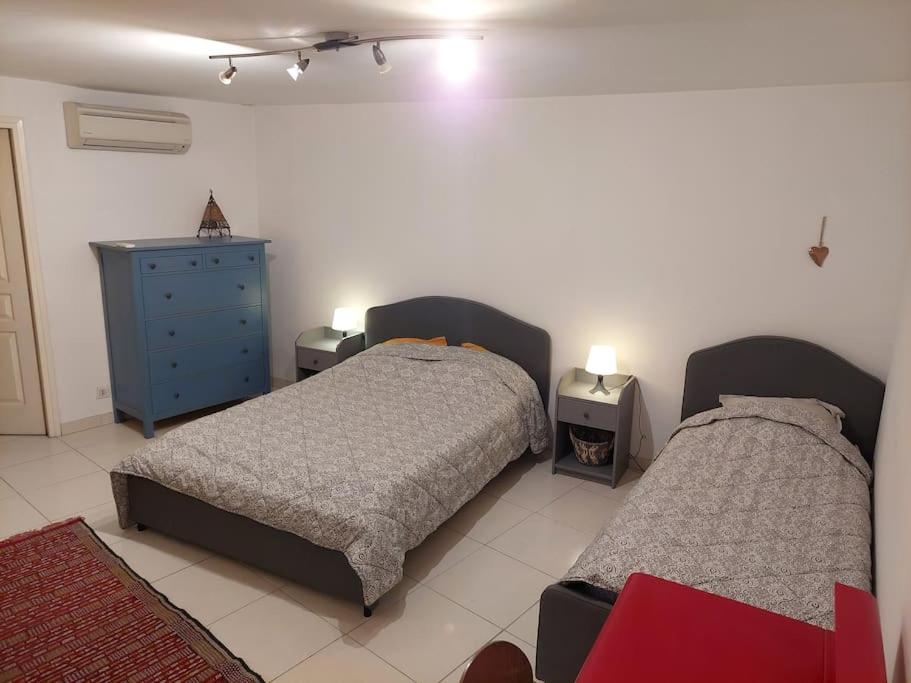 een slaapkamer met 2 bedden en een blauwe dressoir bij L'appartement in Le Pradet