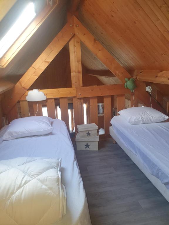 a bedroom with two beds in a attic at Chalet à Cabourg in Cabourg
