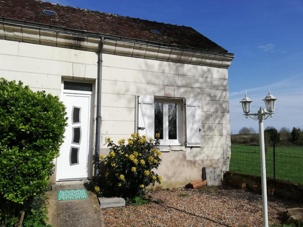 a white house with a white door and a window at Studio, petit déjeuner inclus, 20min Beauval in Faverolles-sur-Cher