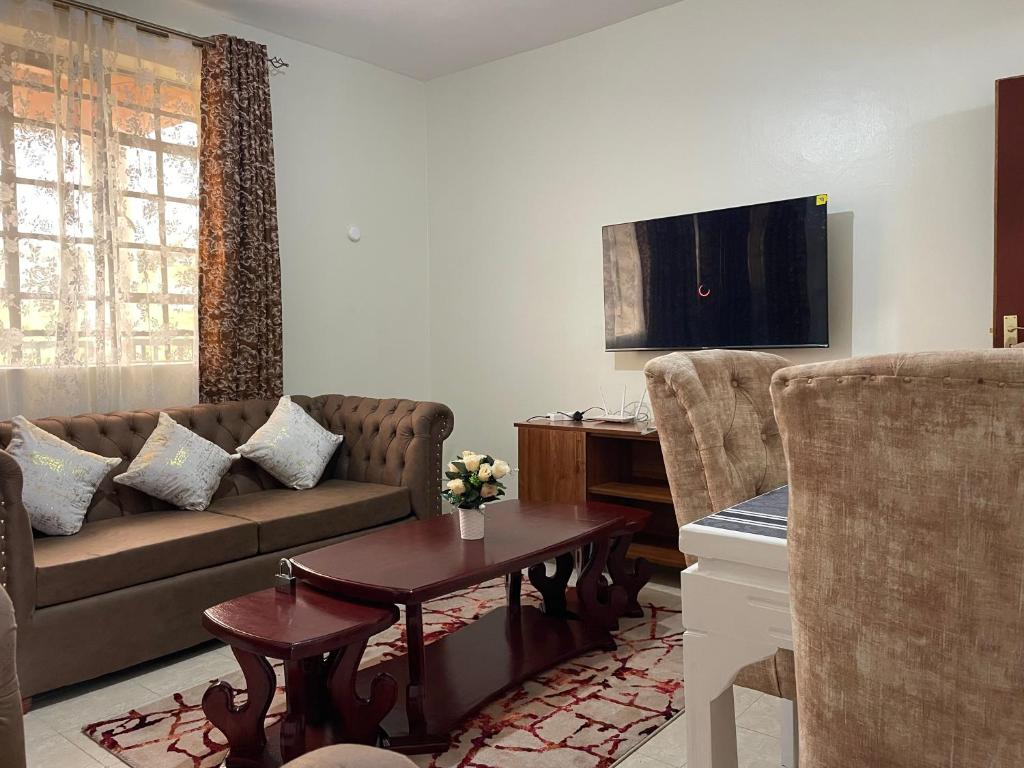 a living room with a couch and two chairs at Dzefry Homes in Nakuru