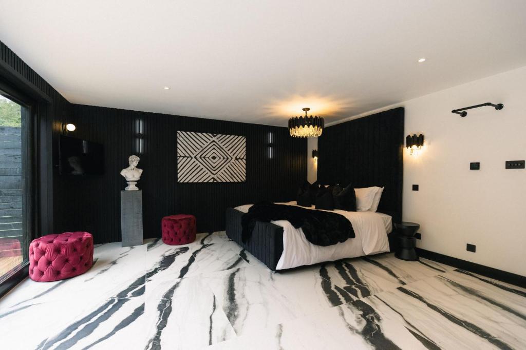 czarno-biała sypialnia z łóżkiem i żyrandolem w obiekcie KOKO Cabins w mieście Copthorne