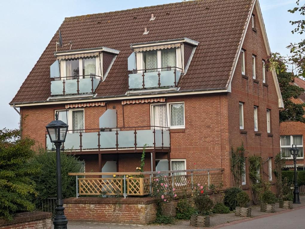 a large red brick house with a balcony at Haus Ekke Nekkepenn I, Whg 7 in Wyk auf Föhr