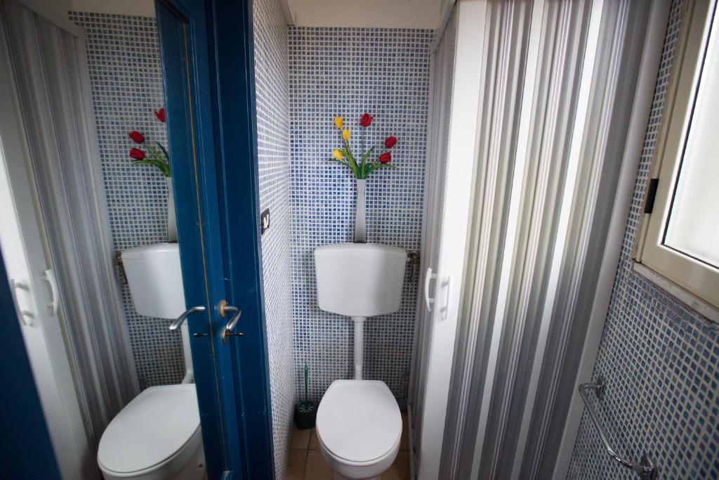 zwei WCs in einem Badezimmer mit Blumen an der Wand in der Unterkunft Sopra La Piazza in Agira