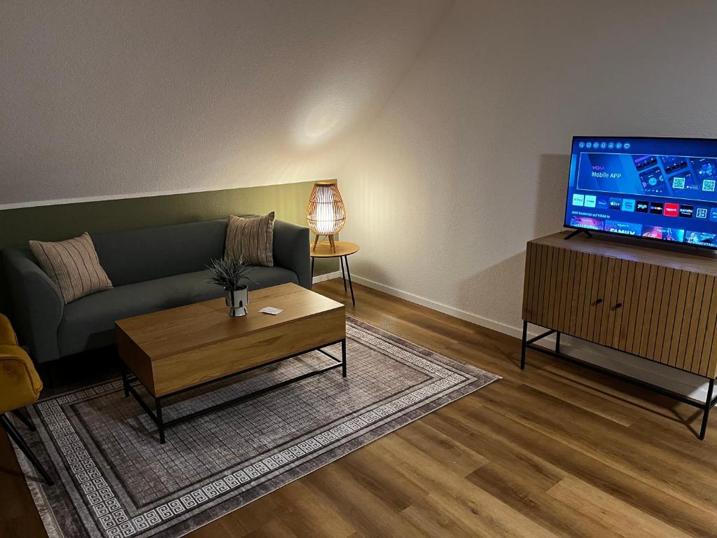 a living room with a couch and a tv at Suite 3 SZ - Lichtenberg in Salzgitter