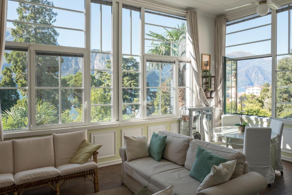 un soggiorno con ampie finestre e un divano di Bellagio Vintage Apartment a Bellagio