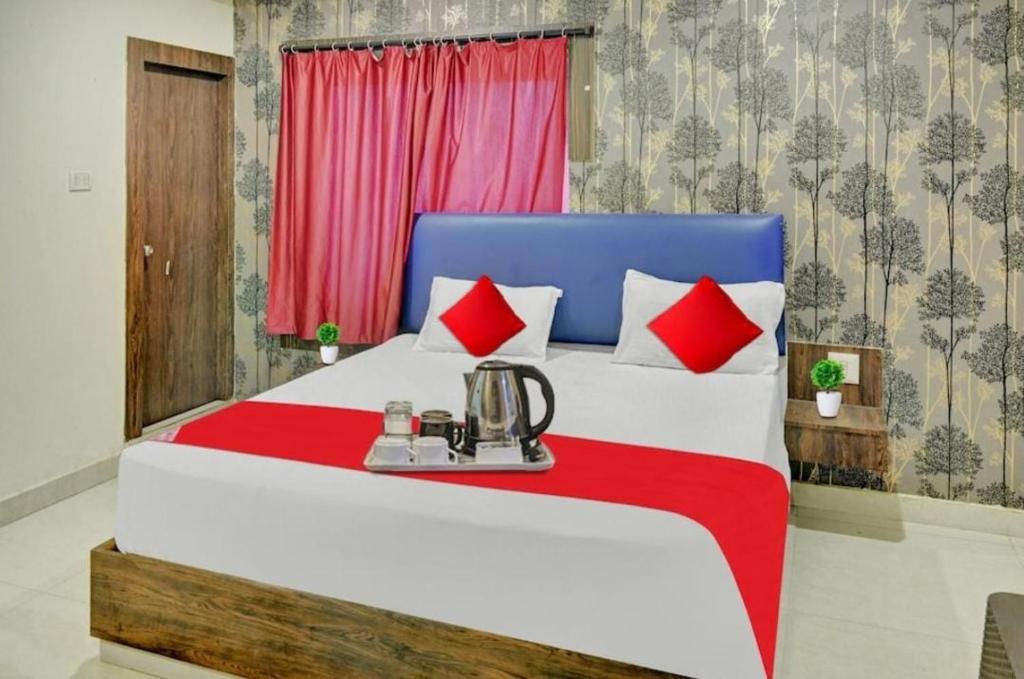 1 dormitorio con 1 cama grande de color rojo y azul en The Royal Comforts, en Visakhapatnam