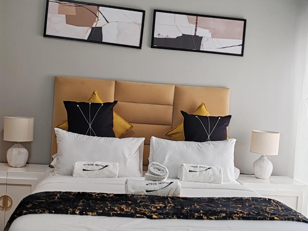 a bedroom with a large white bed with two lamps at Tevin Nest in Sandton
