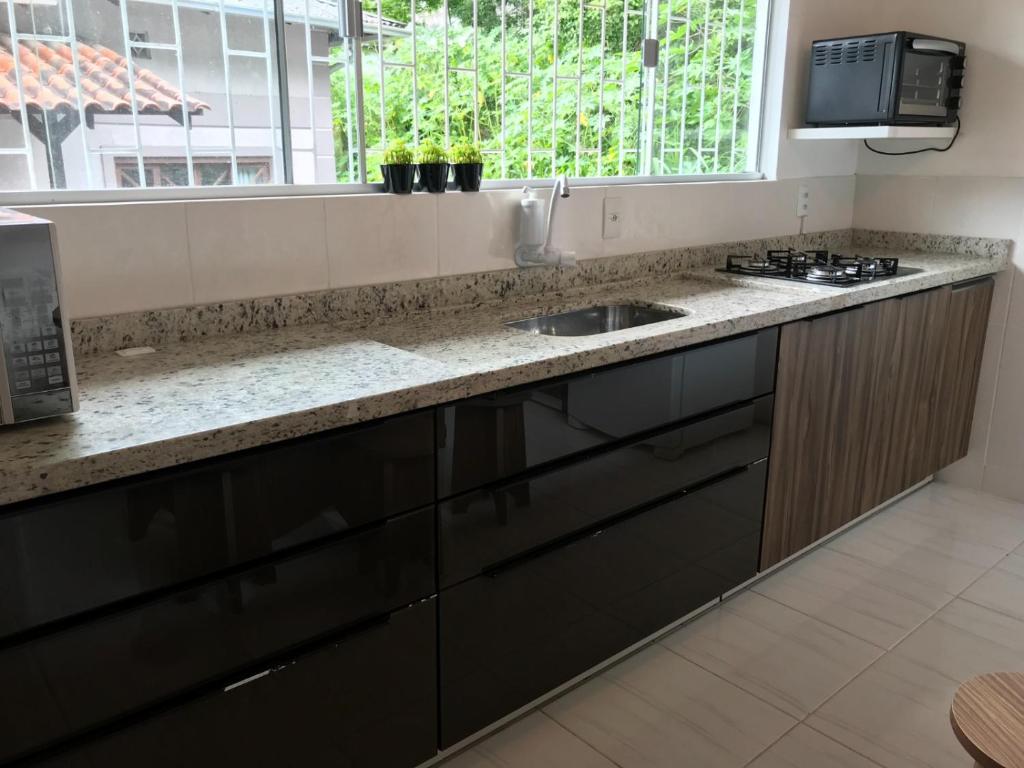 een aanrecht met een wastafel en een raam bij República Descolada! Exclusiva para mulheres! in Florianópolis