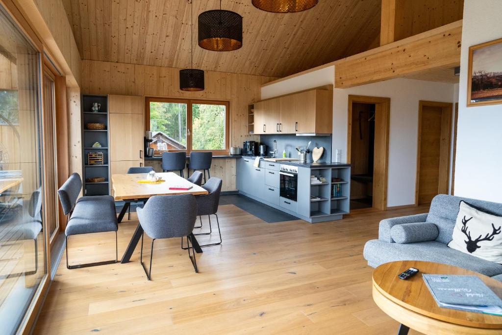 uma sala de estar e cozinha com mesa e cadeiras em Holzhaus "Zum Schwarz'n" em Aurach am Hongar