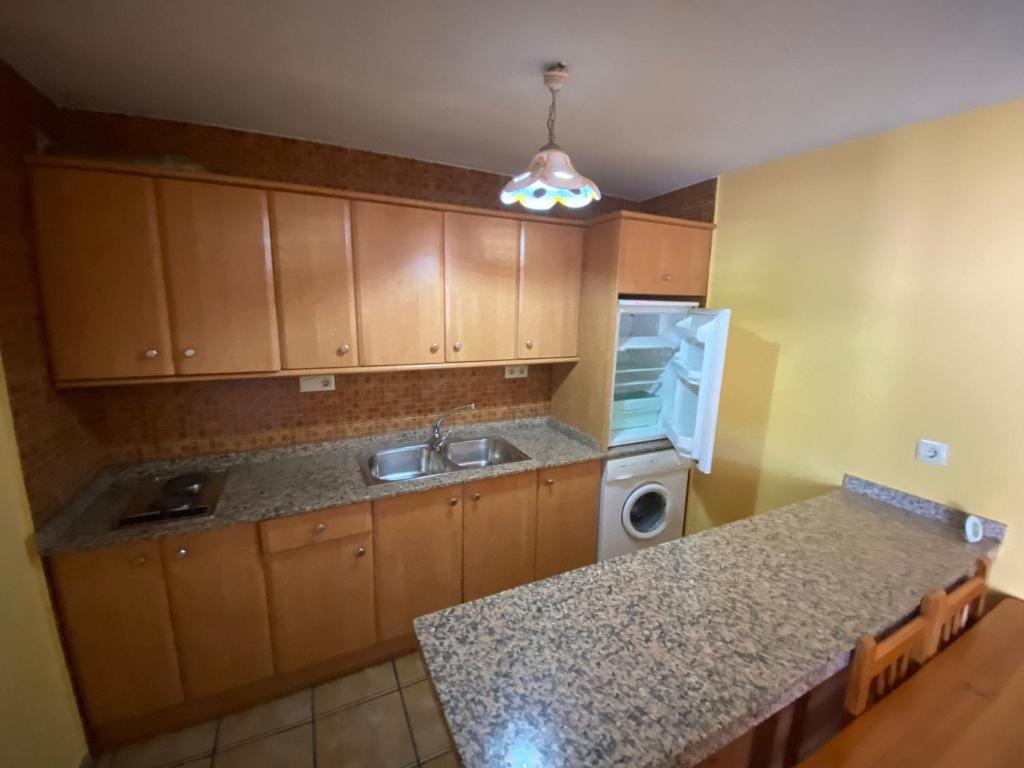 een keuken met een wastafel en een wasmachine bij CASA NICOLAS in Molinicos