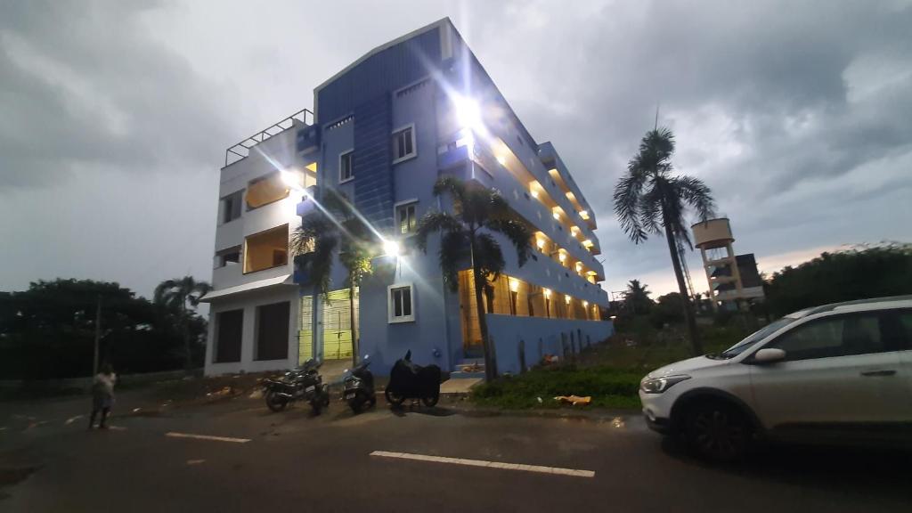 un bâtiment bleu avec des motos garées devant lui dans l'établissement Vikistays, à Chennai