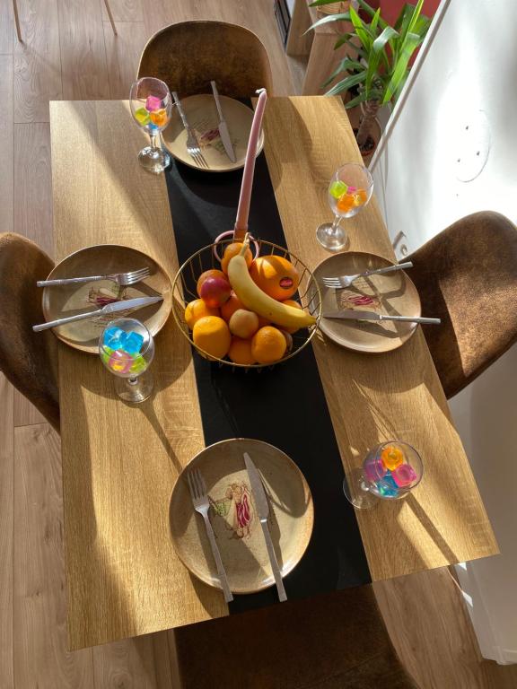 a wooden table with plates of food on it at Cosy home à 20min de paris et orly, Parking gratuit in Antony