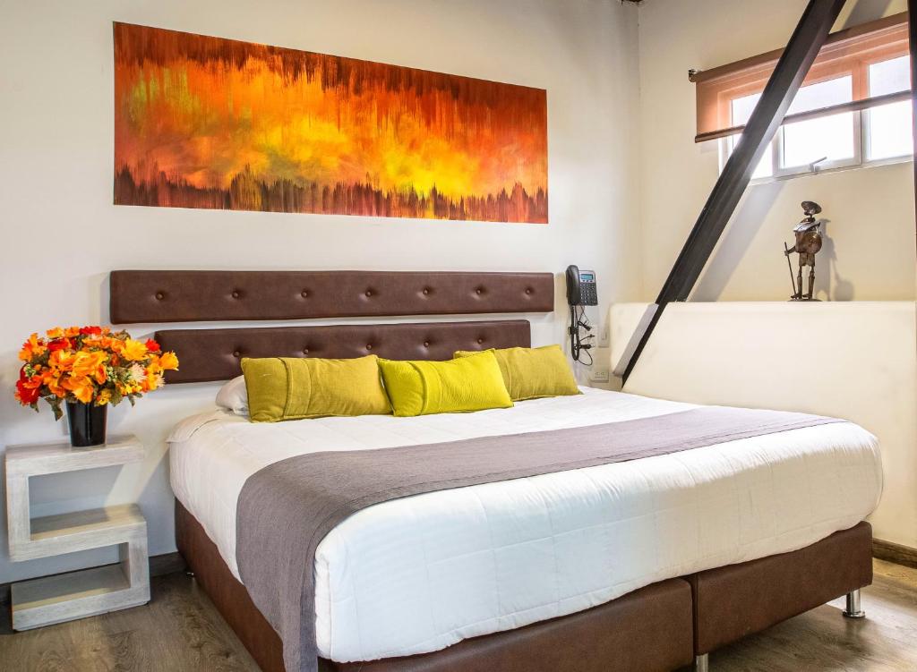 a bedroom with a bed with a painting on the wall at Hotel Wess in Bogotá