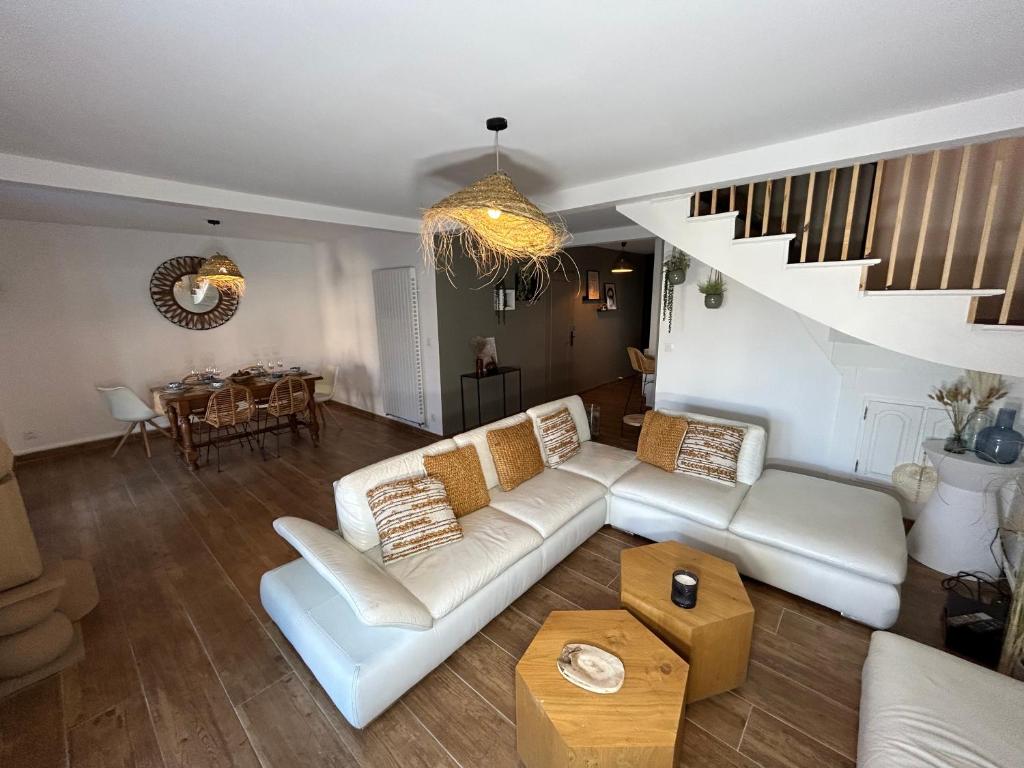 a living room with a white couch and a staircase at VILLA NATURA 3 chambres 80m2 jacuzzy in Canet-en-Roussillon
