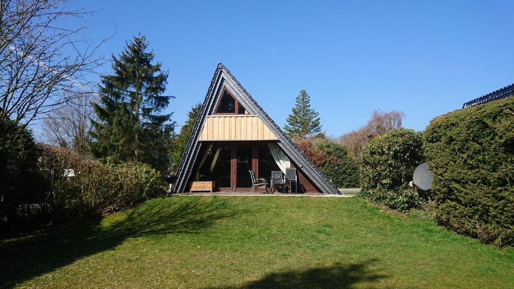 ein Haus mit einem Strohdach auf einem Rasen in der Unterkunft Ferienhaus Freilingen in Blankenheim