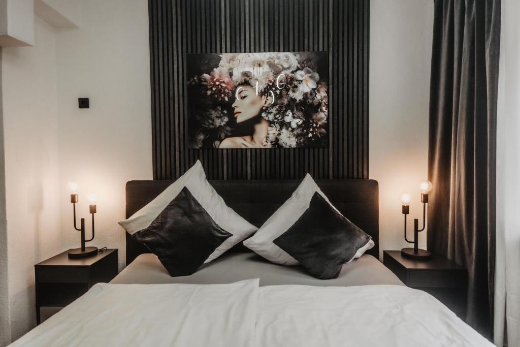 - une chambre avec un lit et une photo de femme dans l'établissement Boutique Hotel Cologne, à Cologne