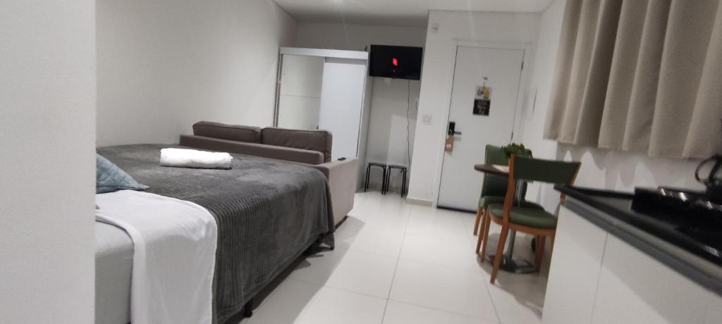um quarto com uma cama, um sofá e uma mesa em La Home House1 - Apto Studio Confortável em SJP - 10 minutos Aeroporto - Curitiba em São José dos Pinhais