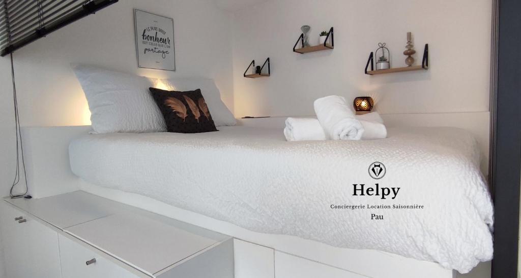 1 cama con sábanas blancas y almohadas en una habitación en Studio cosy rénové-2 pers-Quartier Halles-Bureau, en Pau