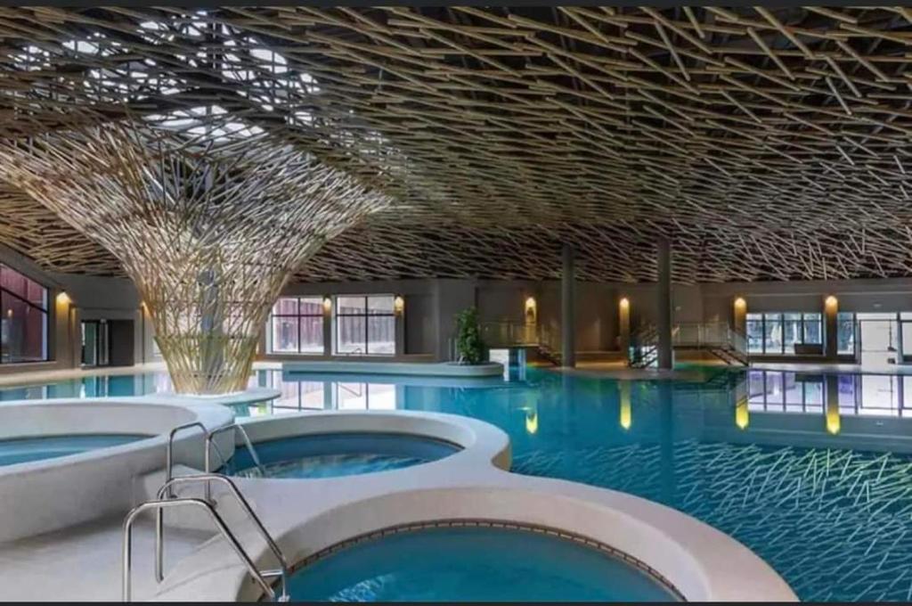 a swimming pool with two hot tubs in a building at F96 TERME OLIMIA, Aqualuna KAMP NATURA PODČETRTEK card included all year in Podčetrtek
