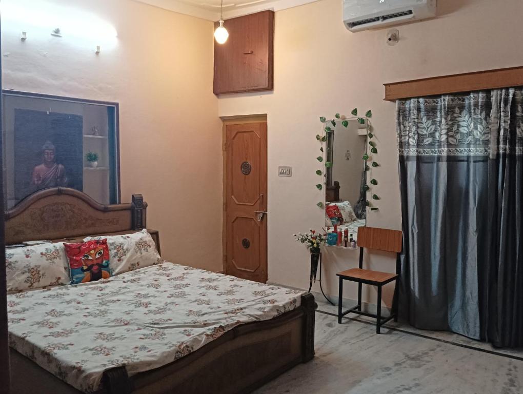 Vanita home stay في أودايبور: غرفة نوم بسرير ومرآة