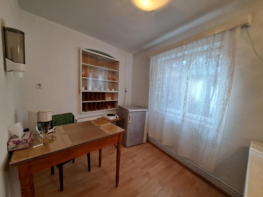 Habitación con mesa, nevera y ventana en Casa Mari en Sibiu